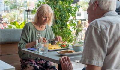 Gast wordt aan tafel bediend bij het raam