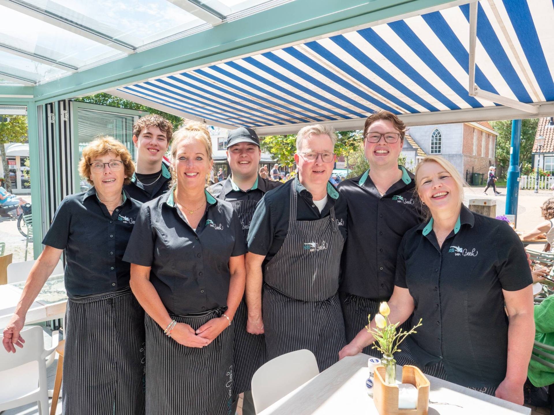 Het team van Vis van Beek samen onder de luifel op het terras