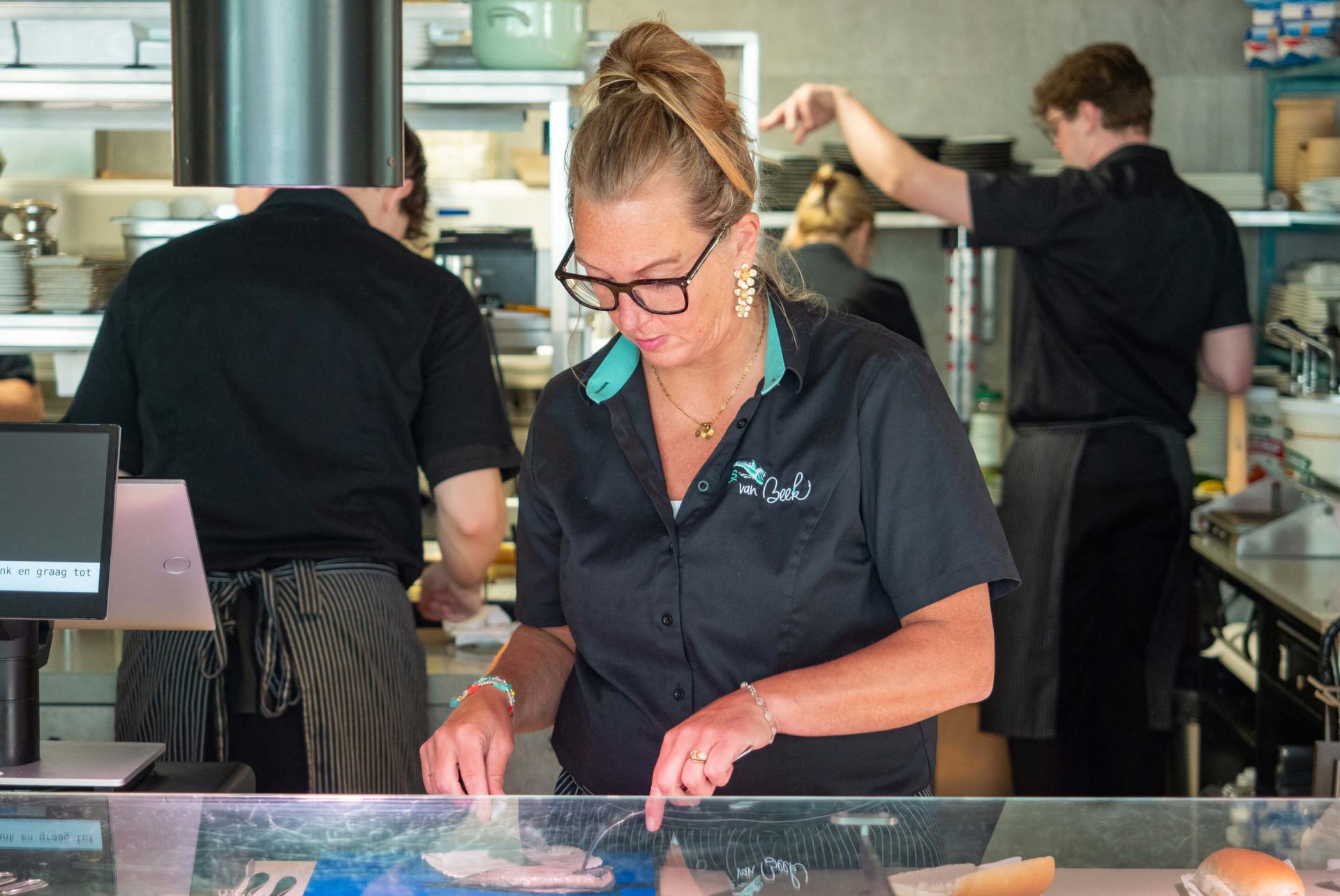 Collega's aan het werk achter de toonbank en in de keuken